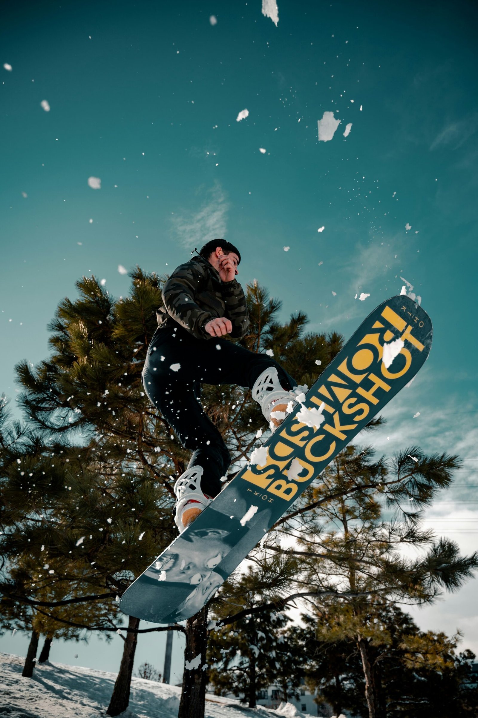 man in black jacket riding blue snowboard during night time